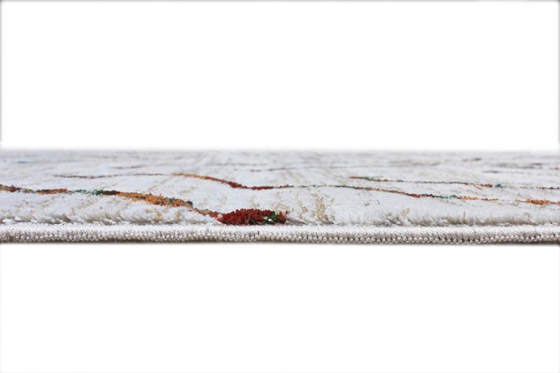 Close up view of white area rug edge with colored pattern