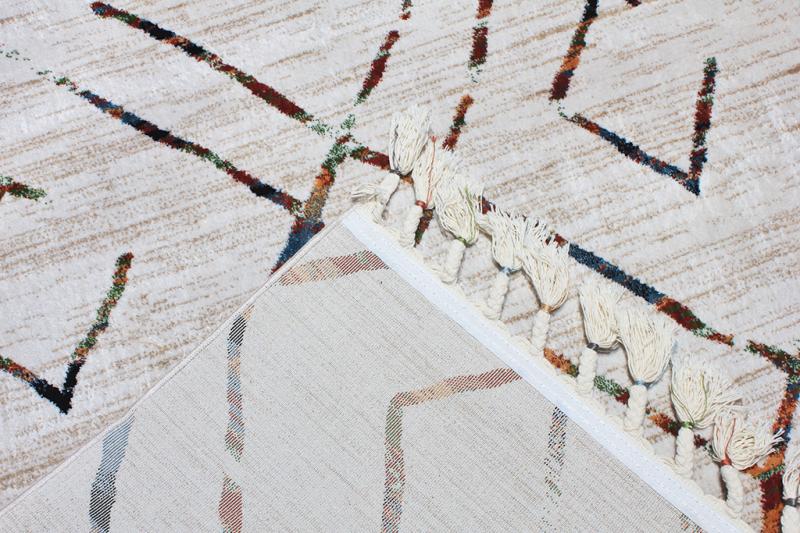 Overhead view of beige rug with multicolored geometric pattern and tassels