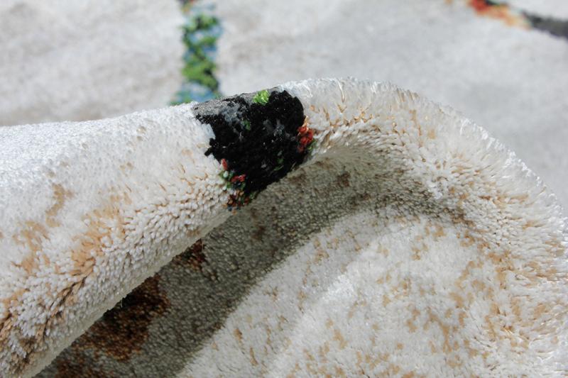 Close up view of white and multicolored area rug pile texture