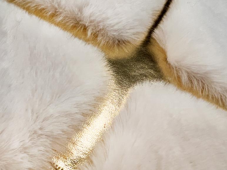 Angled view of Rabbit Fur Rug in a sophisticated bedroom, emphasizing its luxurious presence.