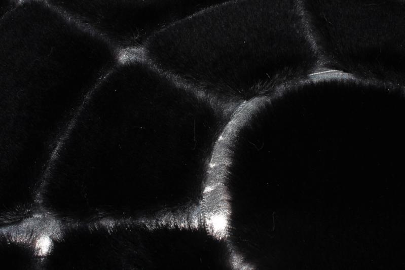 Angled view of Rabbit Round Fur Rug under a small coffee table, showcasing its plushness in a compact setting.