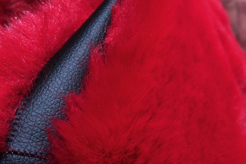 Rabbit Round Fur Rug placed in an eclectic bedroom, adding drama and style with its red and black hues.