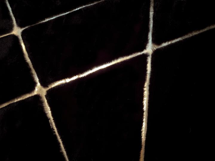 Angled view of Rabbit Fur Rug under a glass coffee table, highlighting its luxurious presence in a contemporary setting.