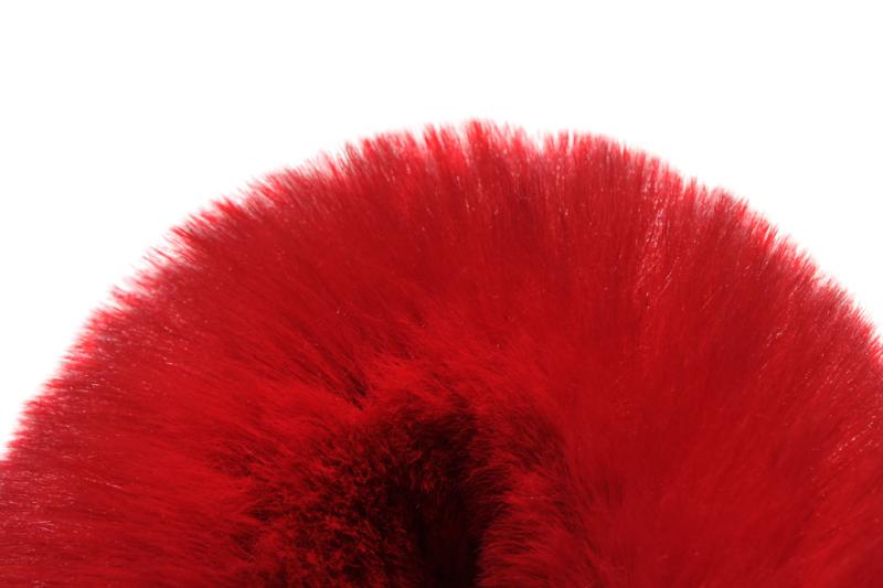 Red faux fur texture close up on white background