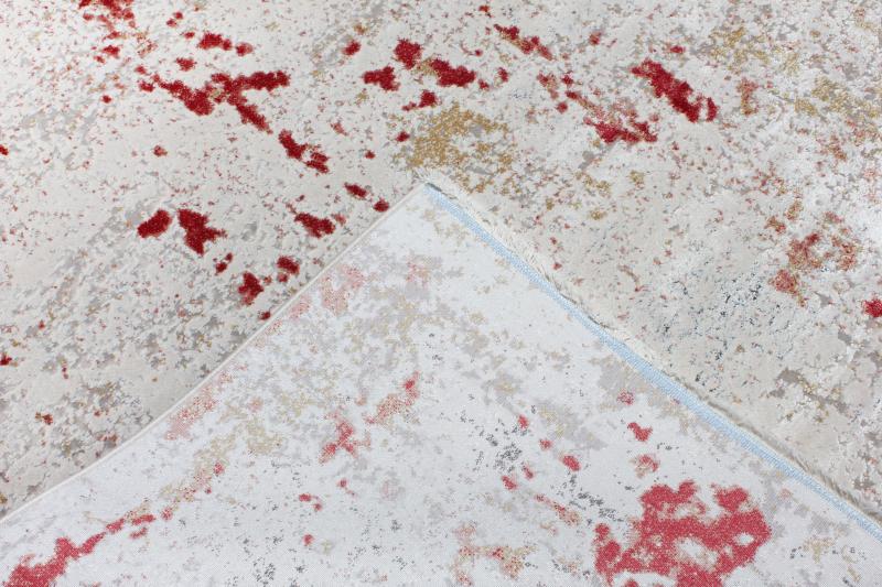 Overhead view of white rug with red abstract pattern