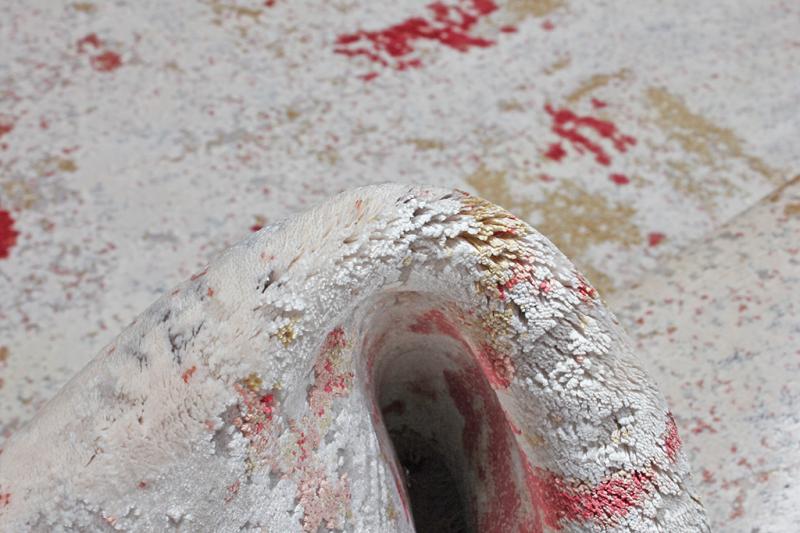 Close up view of rolled white rug with red accents