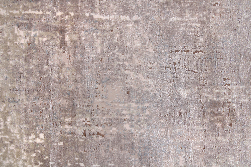 Close up view of abstract patterned rug in gray and brown colors. 