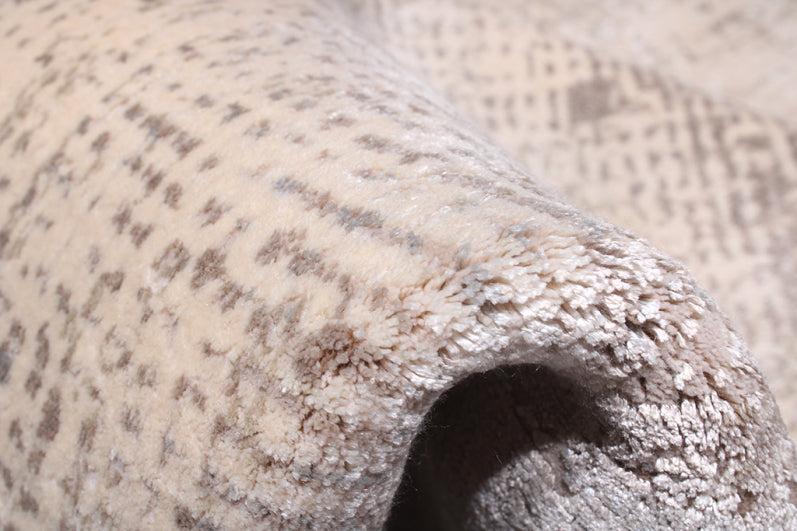 close up view rolled beige area rug spotted pattern texture