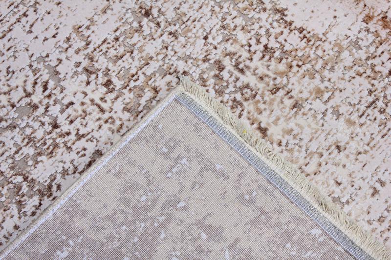 Overhead view of beige and brown patterned rug with turned corner