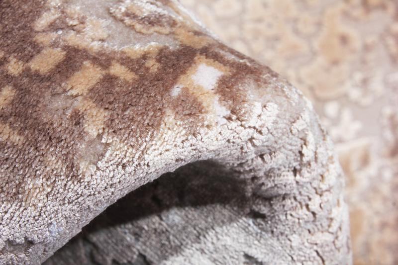 Close up view of rolled brown and beige patterned rug texture