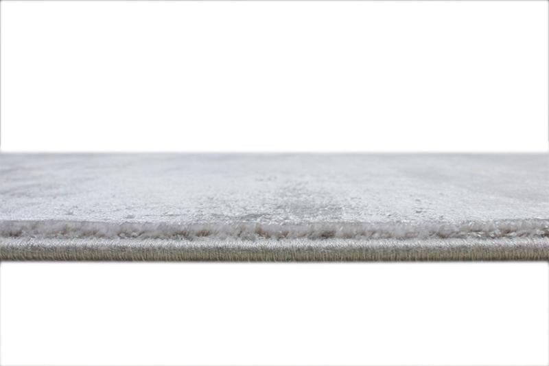 Close up view of light gray rug edge and pile