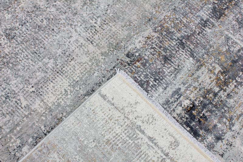 Overhead view of gray abstract patterned rug with fringe
