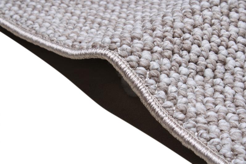 Close up view of beige textured rug edge binding and pile. 