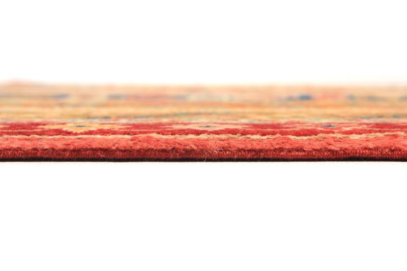 Close up view of red patterned rug edge on white background