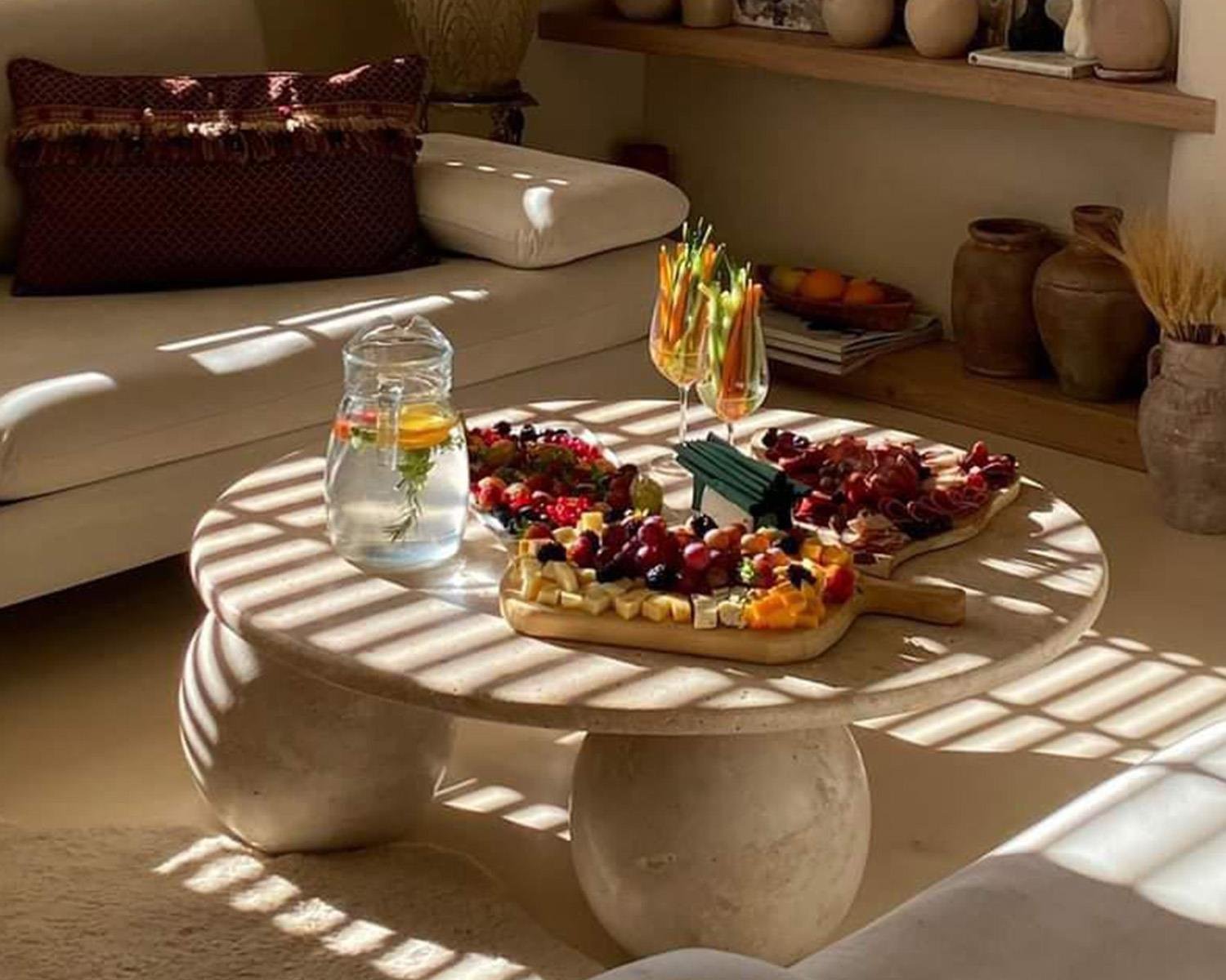Interior view of round stone coffee table with snacks and sofa