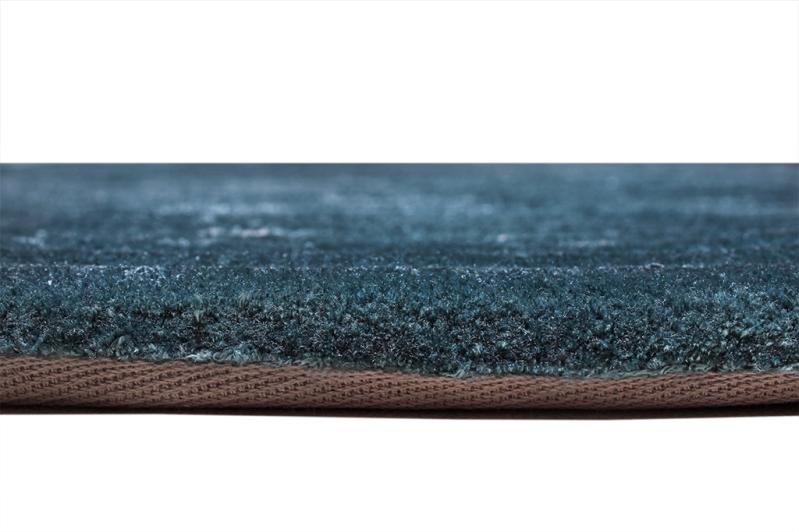 Angled view of Trace Tufted Rug under a wooden coffee table, demonstrating its versatility and sophisticated charm in various settings.