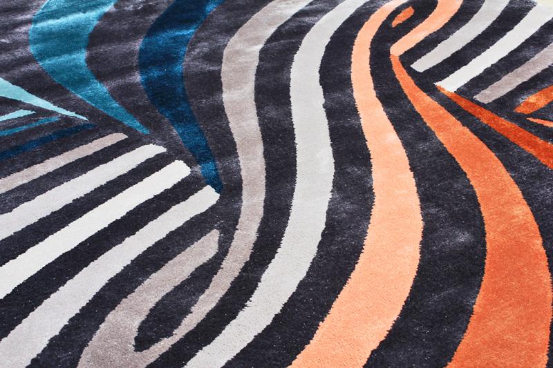 Close up view of a rug with colorful wavy stripes