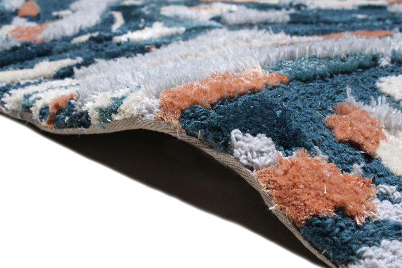 Close-up of the Luzione 902 Rock Tufted Rug showcasing its plush texture, high-pile construction, and blend of blue, orange, and white hues