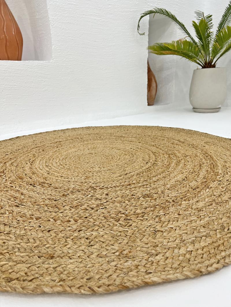 Close up view of round woven jute rug on white floor
