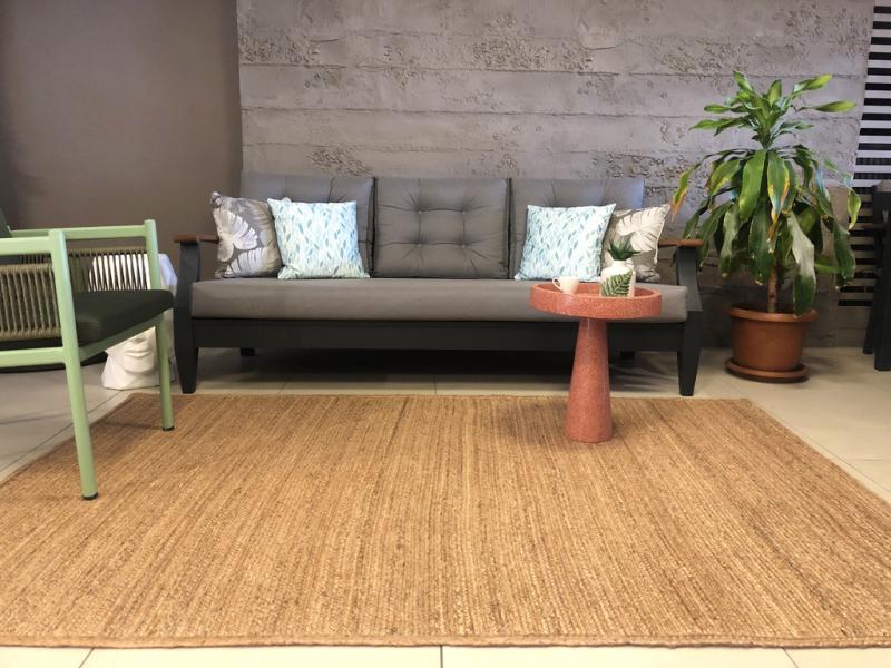 Luzione 908 Urban Rug in a living room with a gray sofa, coral side table, light green chair, and potted plant, showcasing modern home decor