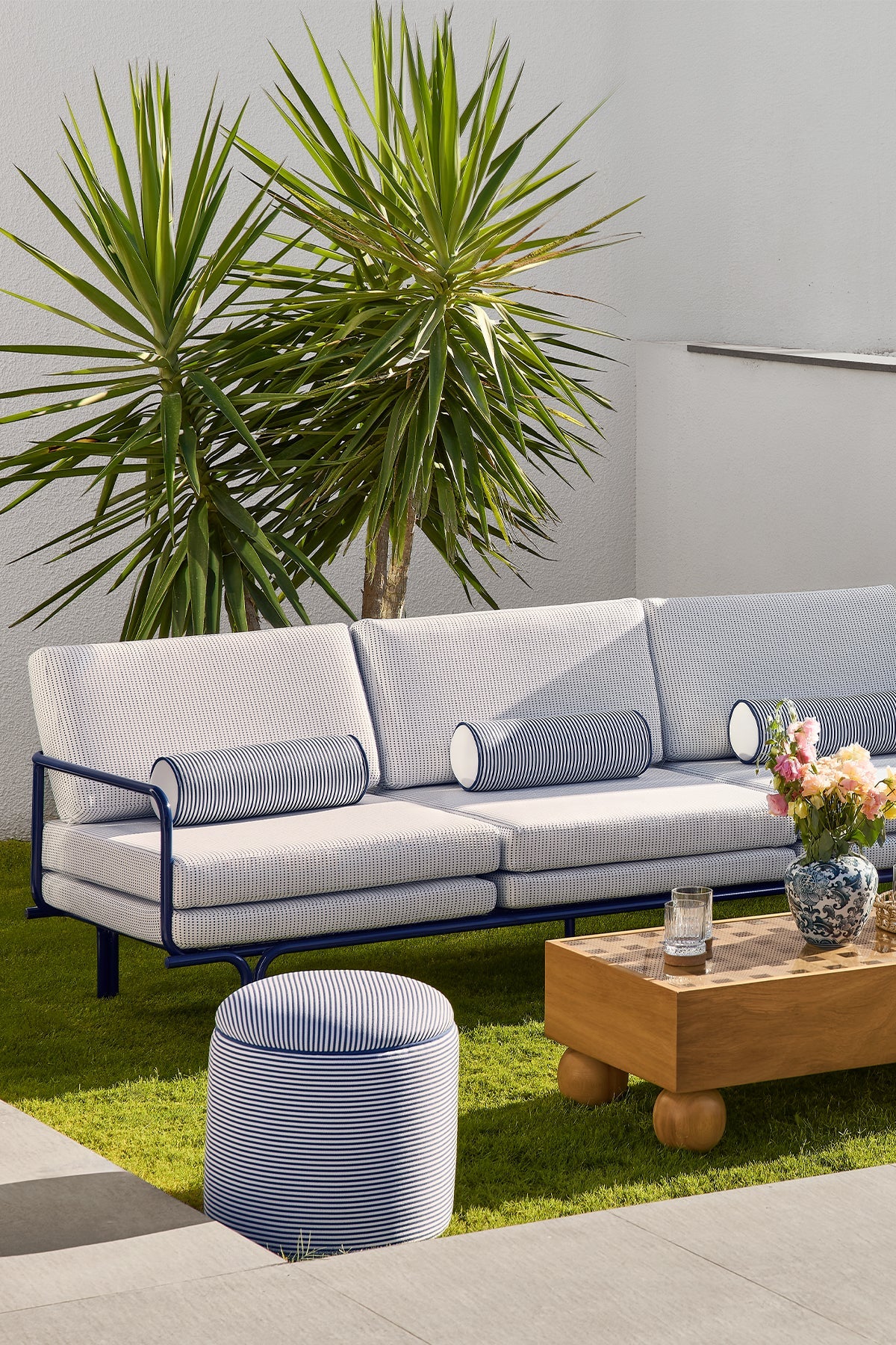 Bari pouf placed beside a modern outdoor seating set.