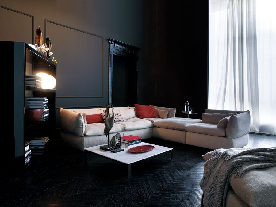 Dark living room interior with light sectional sofa and marble coffee table. 