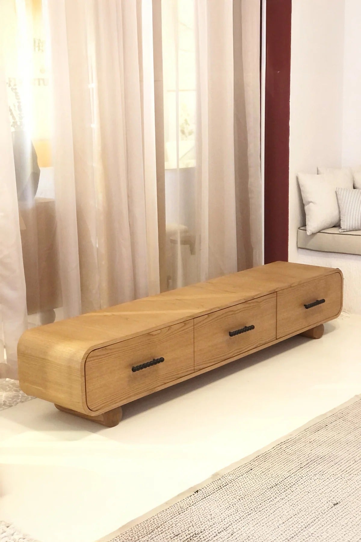Long wooden console with three drawers and black handles