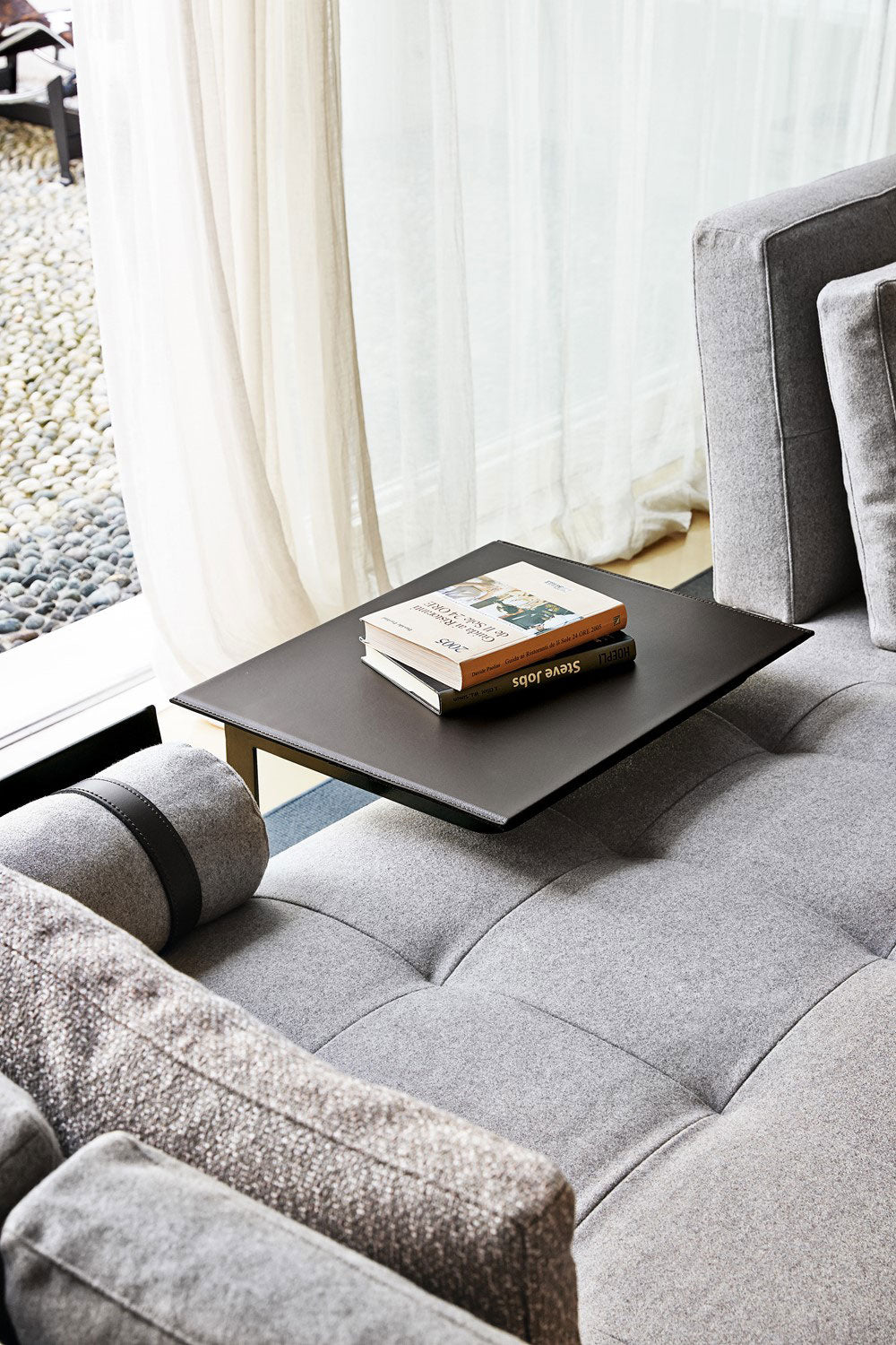 Close up view of gray upholstered sofa with black side table