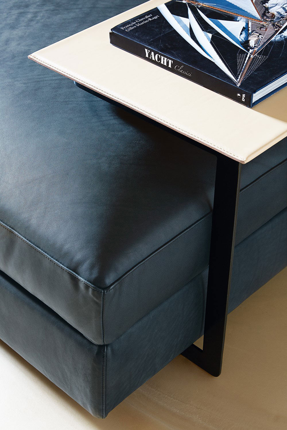 Close up view of blue leather ottoman with side table