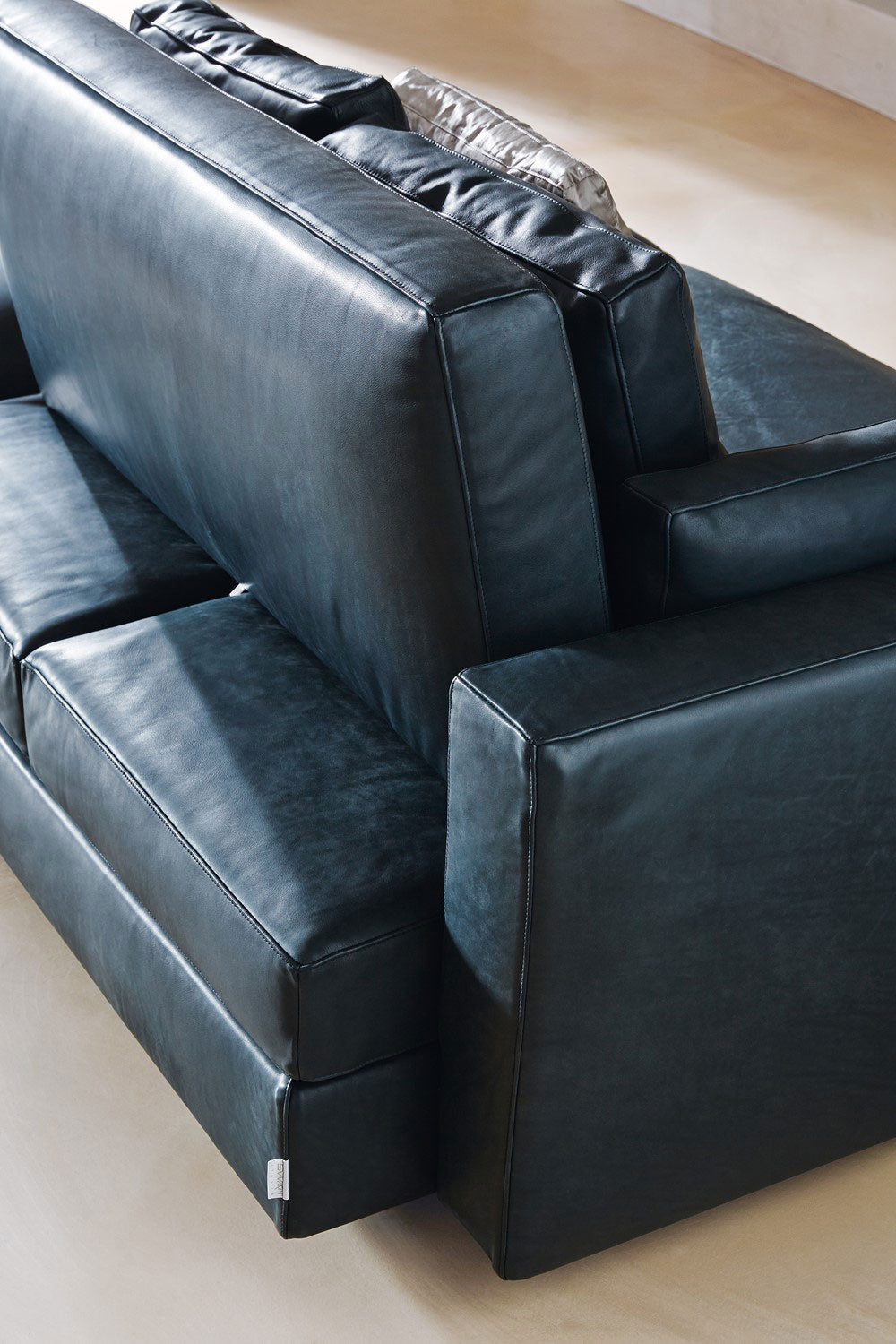 Close up view of black leather sofa backrest and armrest