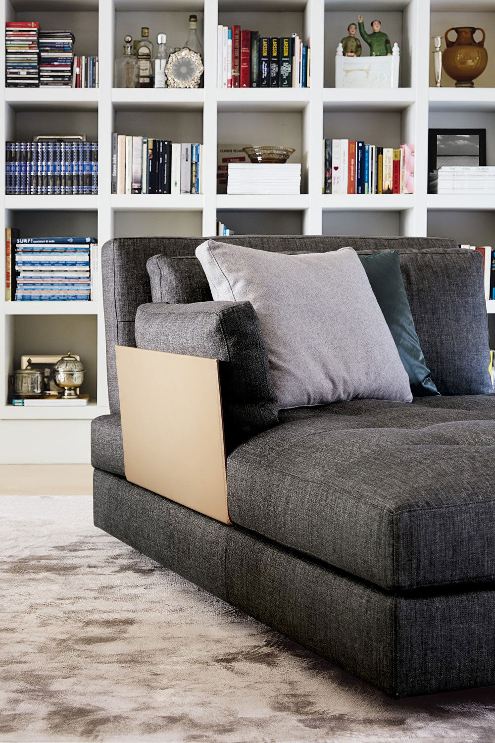 Close up of dark gray fabric sofa with beige leather armrest.