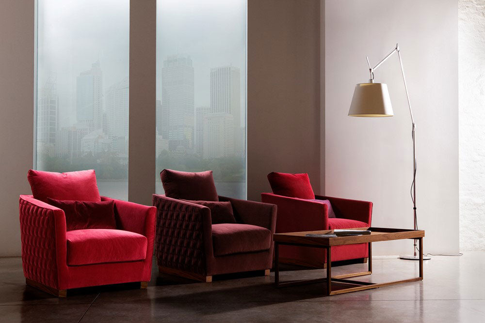 Interior view, three red velvet armchairs, wood coffee table, floor lamp, city view.