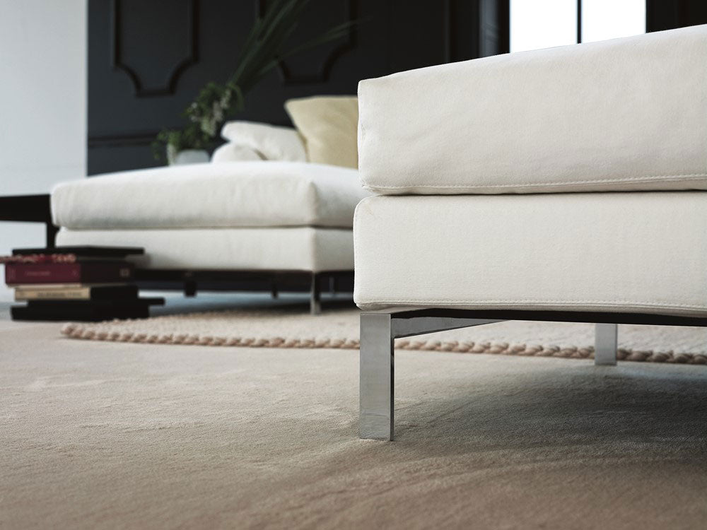Close up view of white sofa with metal legs on beige rug
