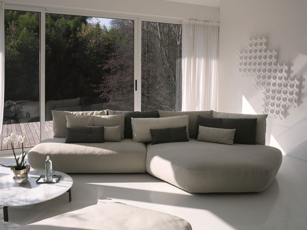 Modern sectional sofa with pillows and round marble coffee table