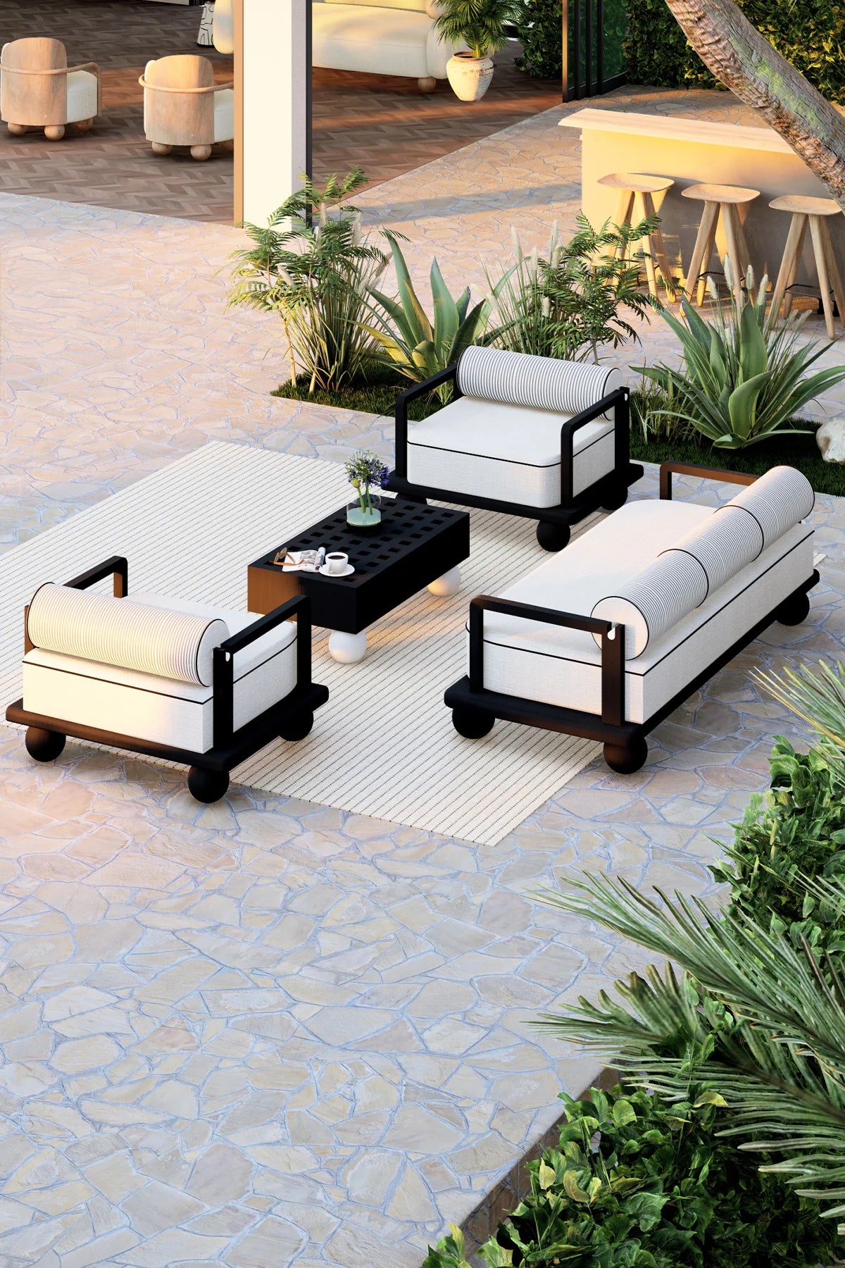 Outdoor patio set with white cushions on a stone patio