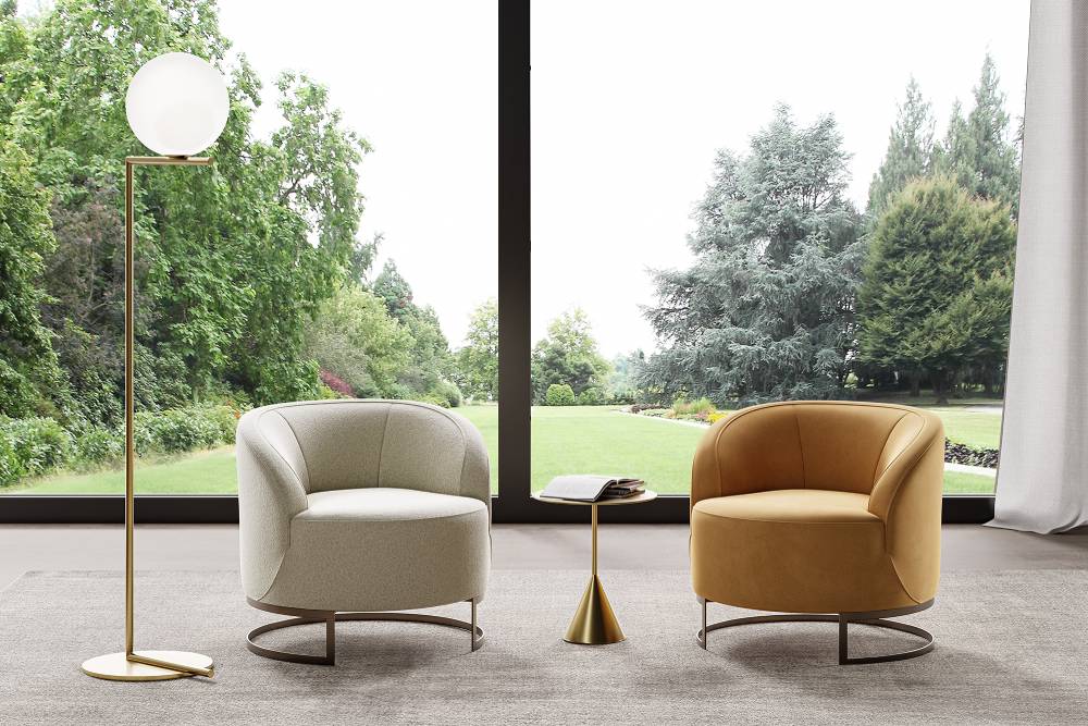 Interior view of two upholstered armchairs, floor lamp, side table, rug, window overlooking garden