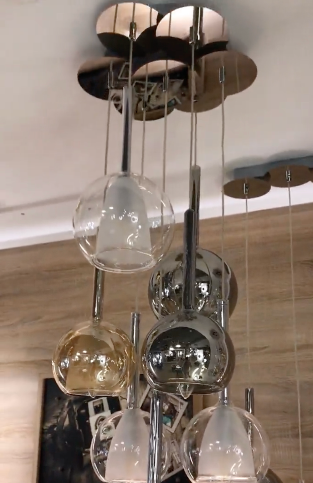 Close up view of multi-colored glass globe pendant lighting fixture hanging from ceiling, modern lighting, contemporary furniture, interior design, home decor, glass globes, chrome accents.