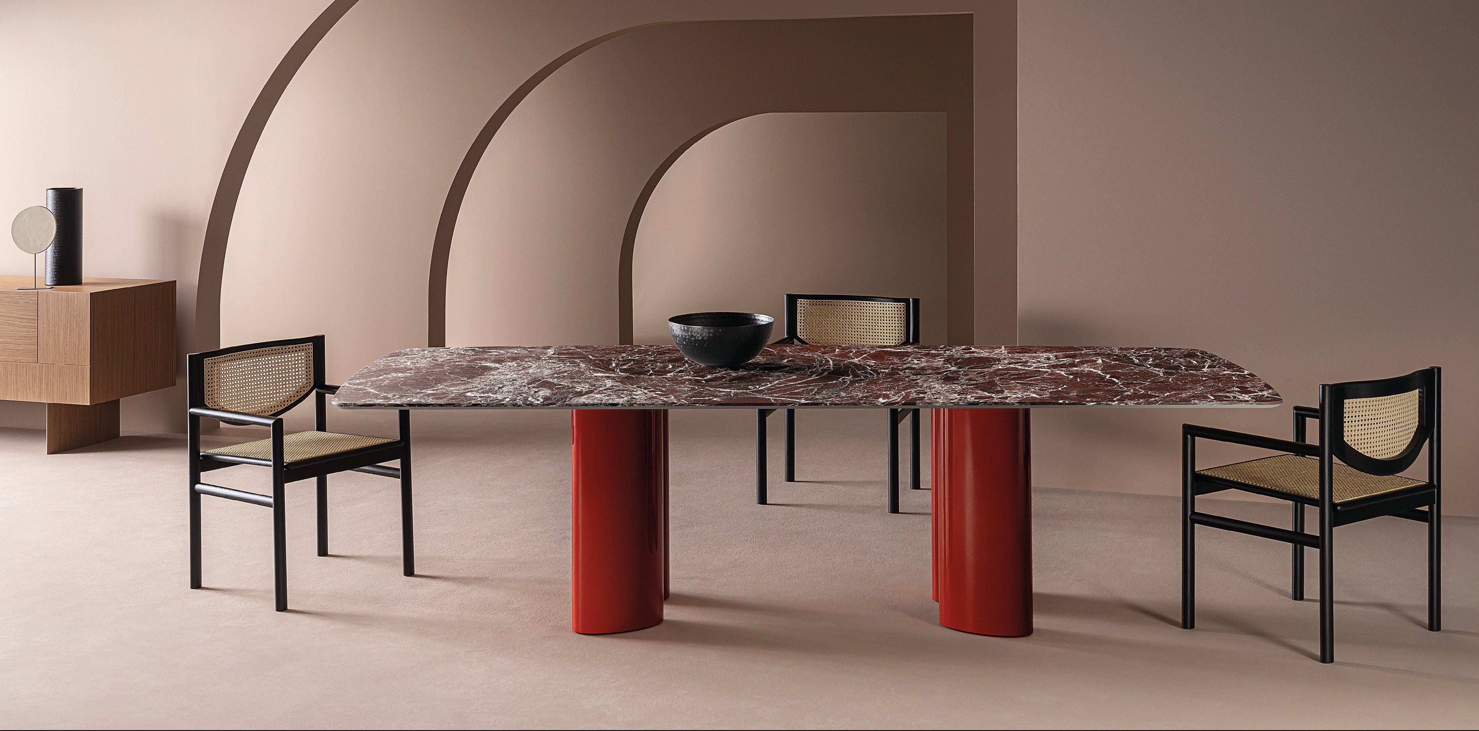 Modern furniture set with a large marble table and rattan chairs in a minimalistic room.