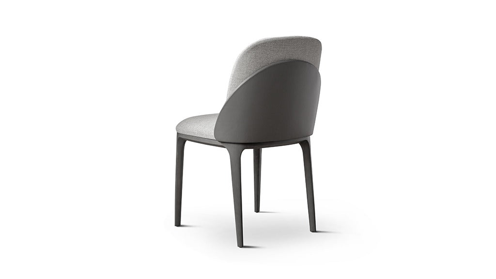 Back view of gray upholstered dining chair with dark shell and legs. 