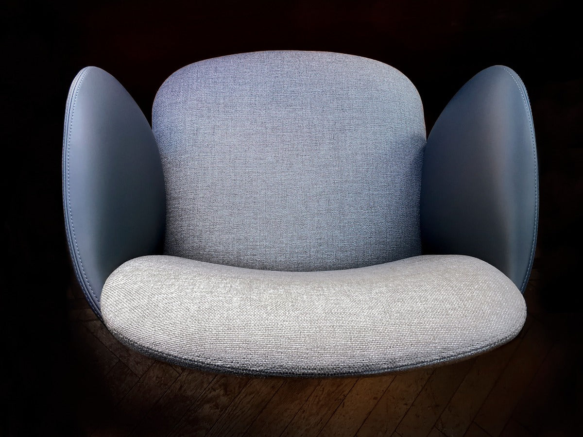 Close up view of blue fabric and leather armchair on wood floor. 