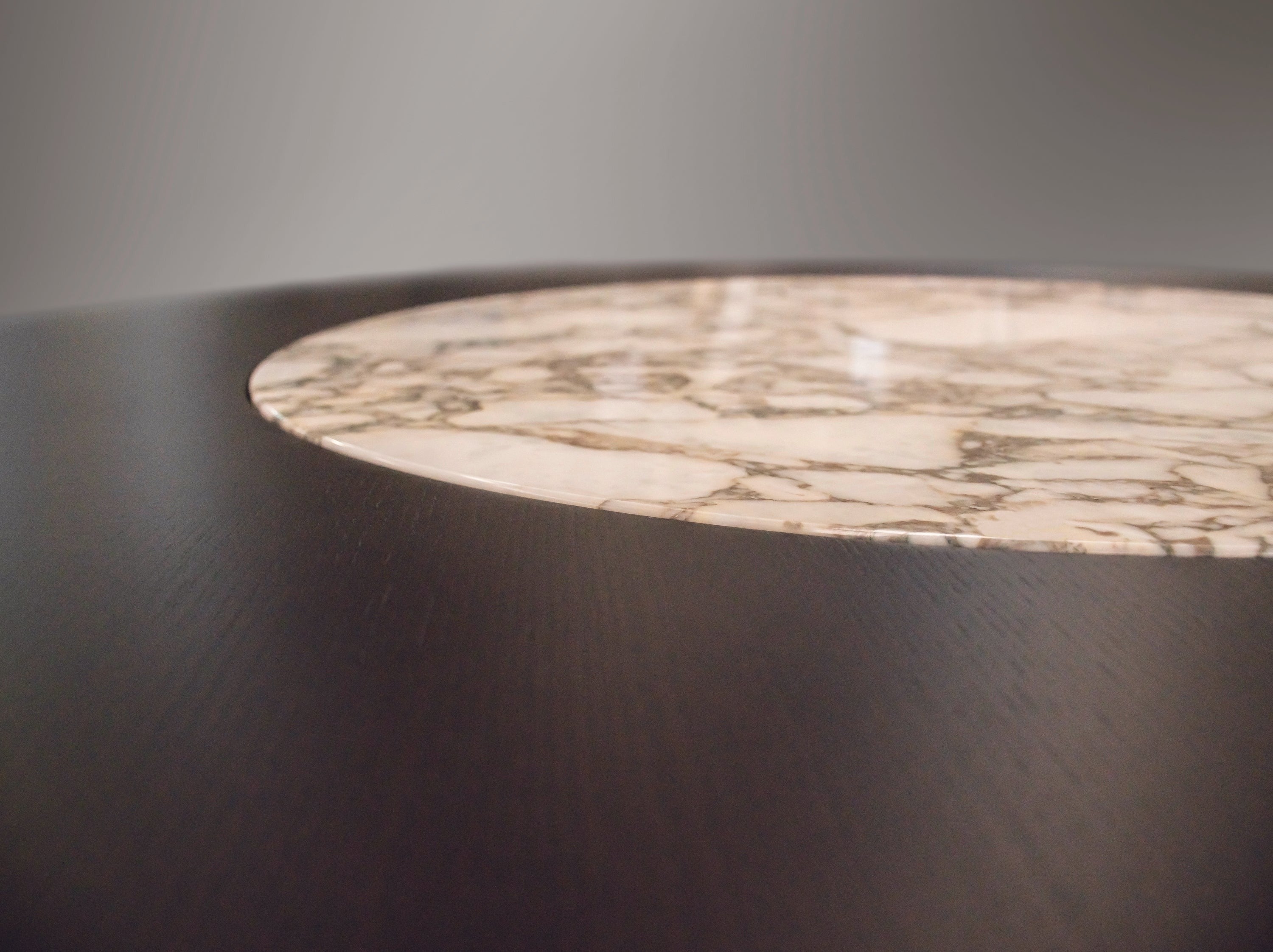 Close up of round wood table with marble insert