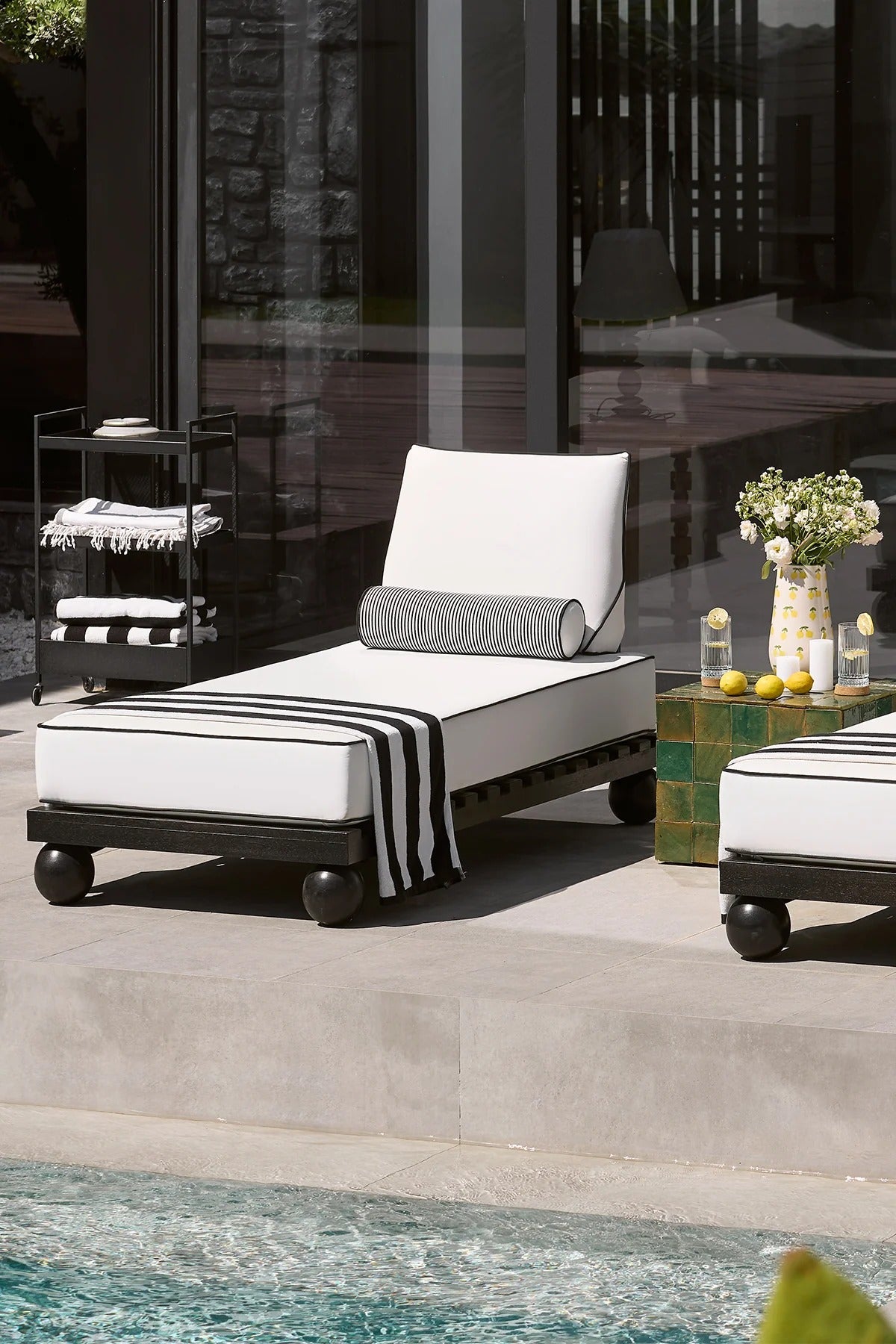 Outdoor lounge chair with cushions by a poolside