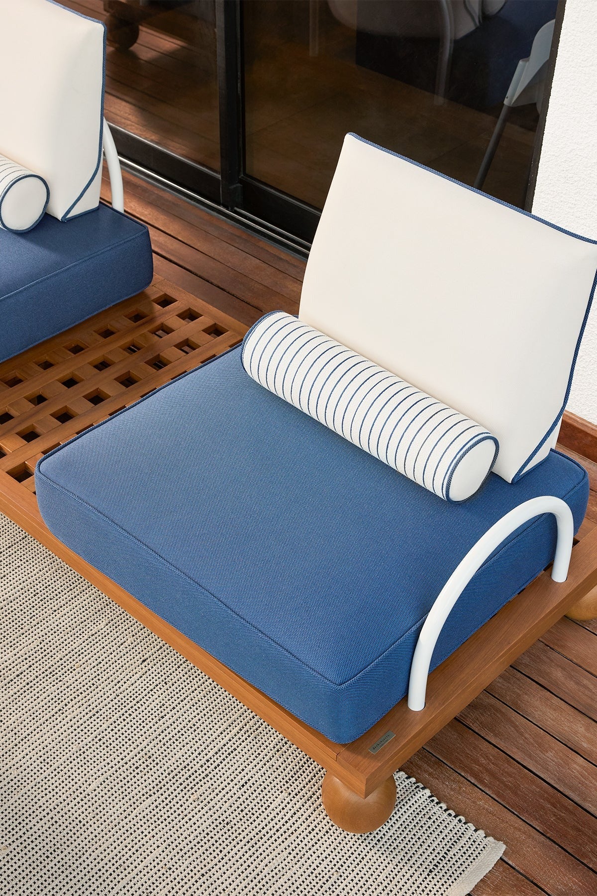 Blue outdoor cushion with white frame on a wooden chair