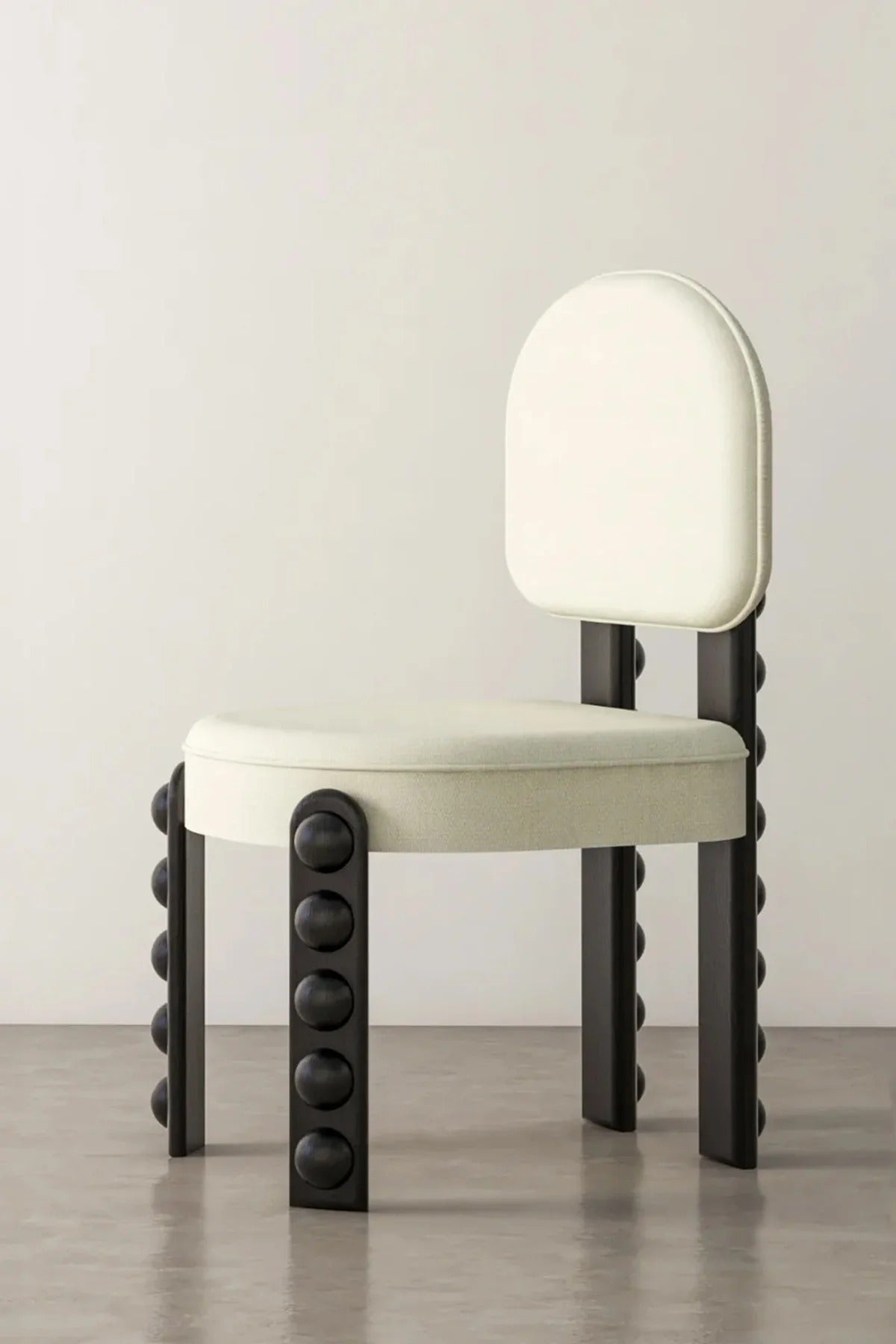 White upholstered chair with dark wood legs and sphere details