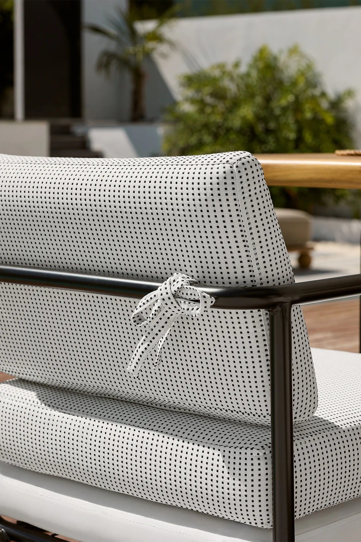 Gray cushion with black patterns on a chair outdoors