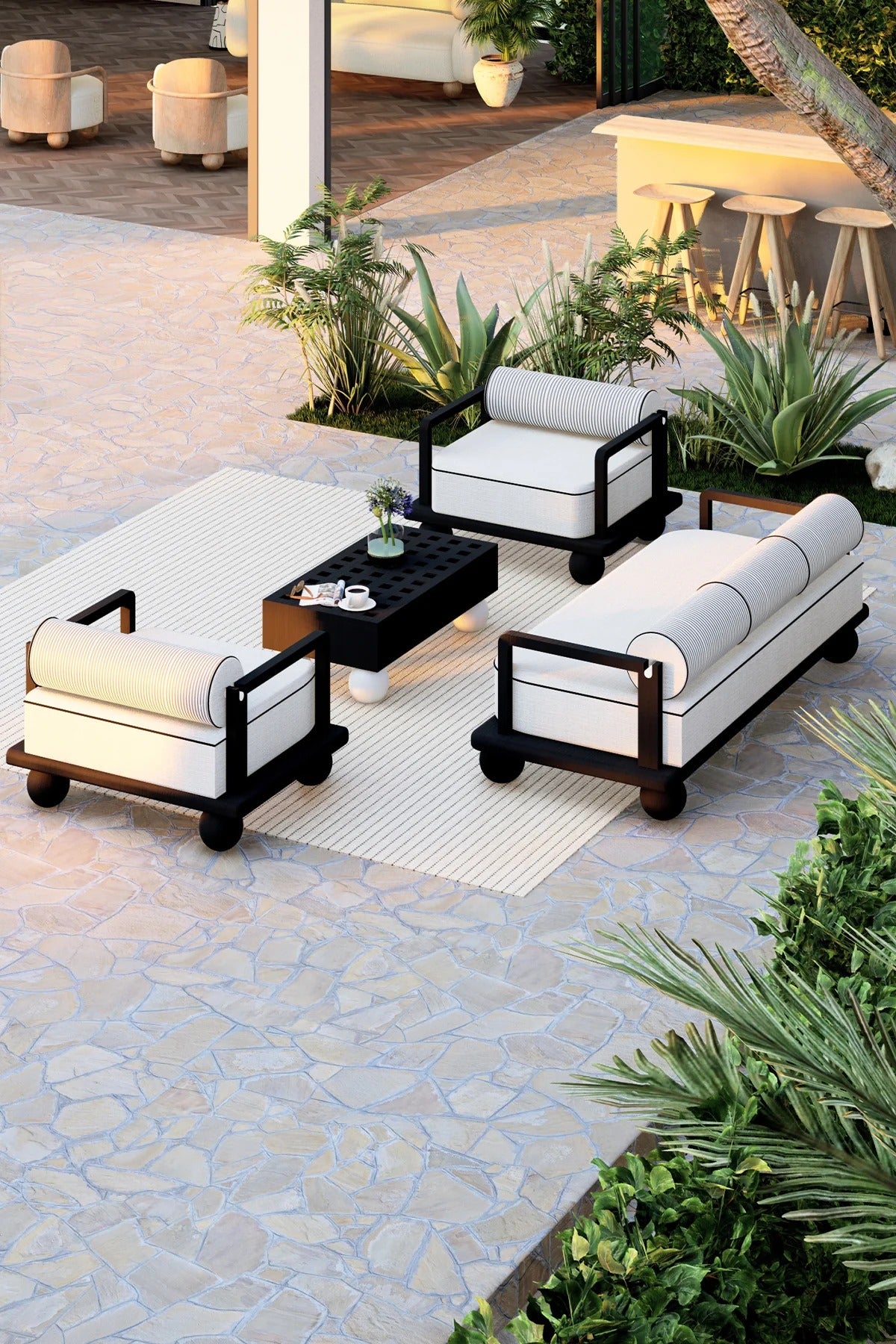 Outdoor patio seating set with white cushions on a stone patio